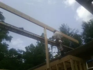 Carpenter setting a ridge beam over a new addition frame — Ice Dam Removal by Roofing Brothers in Westfield